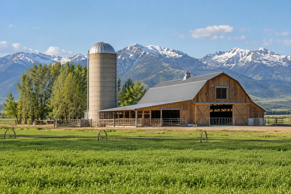 Tidy farmstead with a dairy barn and silo among irrigated fields in spring